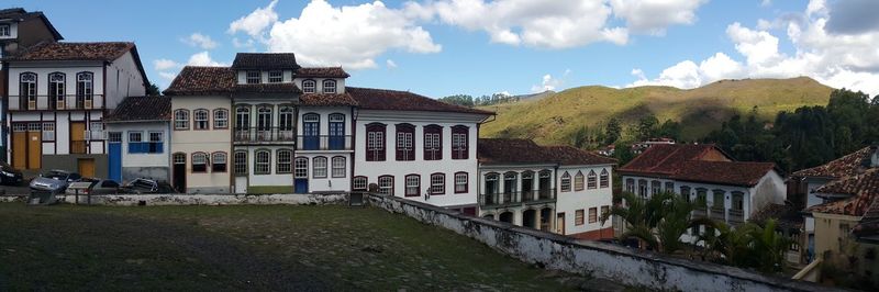 Houses by mountain against sky