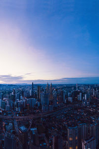 Aerial view of buildings in city against sky during dusk