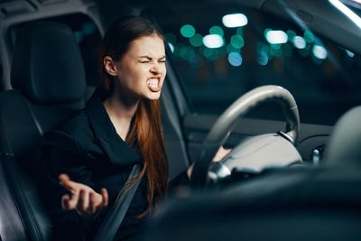 Angry woman sitting in car