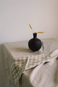 Modern dining table setting. a beautiful black vase with a linen napkin on the table.