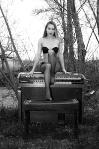 Portrait of seductive woman sitting on piano