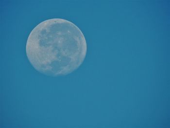 Low angle view of moon against blue sky