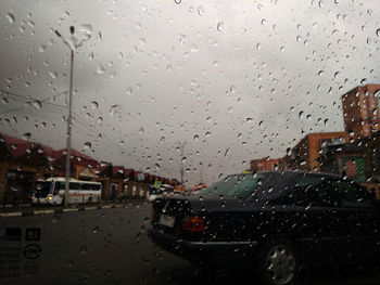 City seen through wet glass window during rainy season