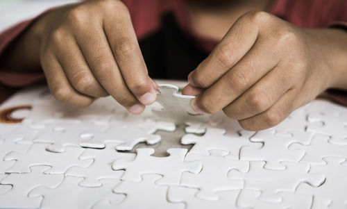 Cropped hands arranging jigsaw pieces