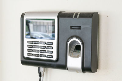 Close-up of telephone booth against wall