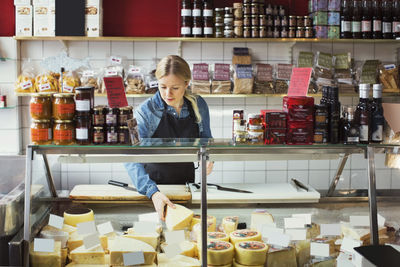 Saleswoman working at display cabinet in supermarket