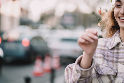 Portrait of young woman standing in the street with a sparkler in hand