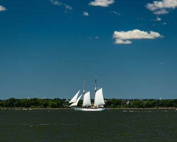 Sailboat sailing on sea against blue sky