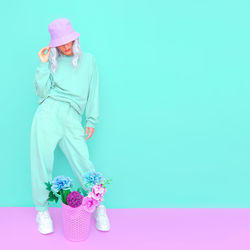 Woman with pink flowers against blue background