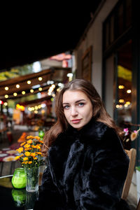 Portrait of beautiful woman in city at night