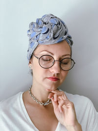 Portrait of young woman in neutral colors. candid millennial woman wearing african style headscarf. 