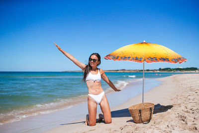 Rear view of woman with umbrella at beach