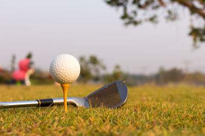 Close-up of golf ball and swing on grass