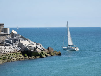 Sailboat sailing on sea against sky