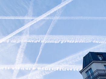 Low angle view of vapor trails against sky during winter