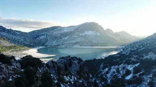 Scenic view of lake and snowcapped mountains against sky