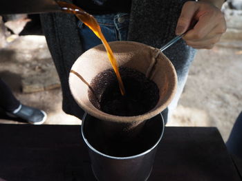 Hand holding coffee cup on table
