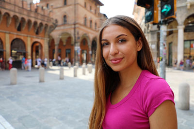 Portrait of smiling young woman in city