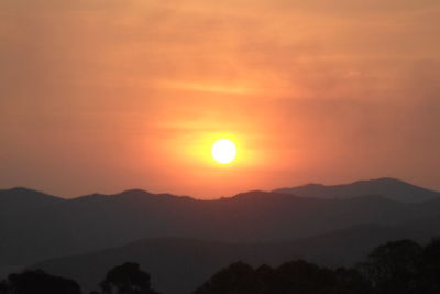 Scenic view of silhouette mountains against romantic sky at sunset