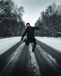 Full length of man on snow covered road