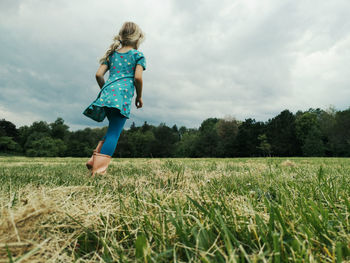 Cute little girl run on meadow. kids girl legs feet in rain boots. freedom innocence and adolescense 