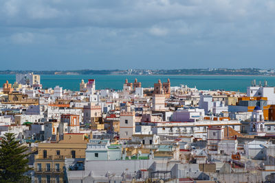 High angle view of townscape by sea against sky