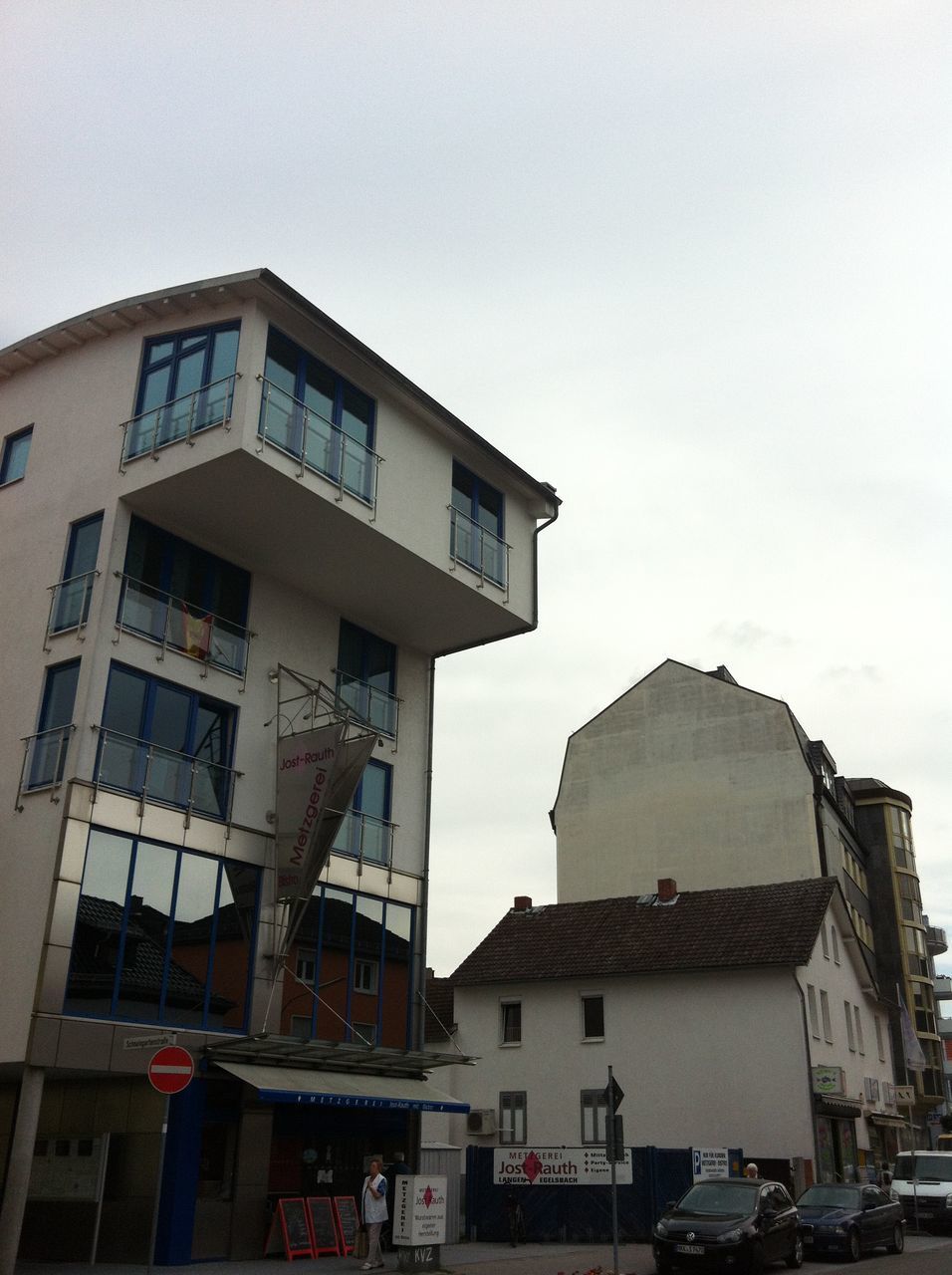 LOW ANGLE VIEW OF BUILDING BY STREET AGAINST SKY