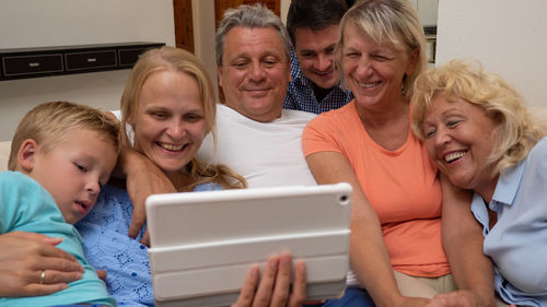 Happy family watching movie in digital tablet at home