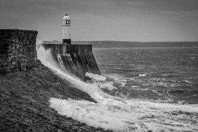 Lighthouse on shore against sky