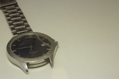 Close-up of clock on table against white background