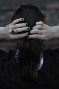 Rear view of woman tying hair