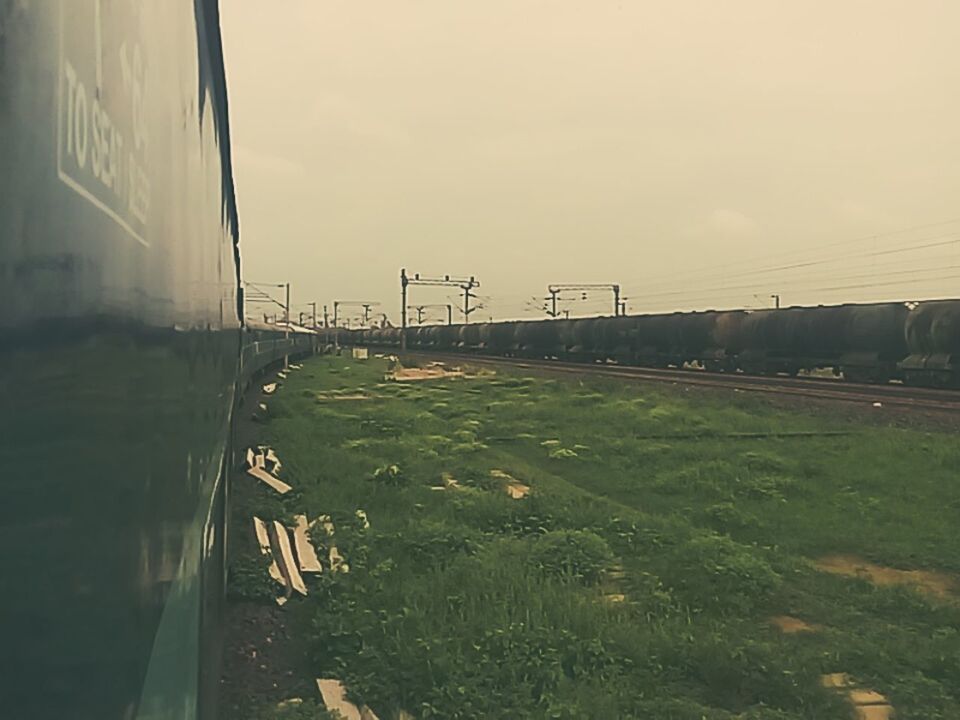 TRAIN AT RAILROAD TRACKS AGAINST SKY