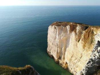 High angle view of rock formation in sea against sky