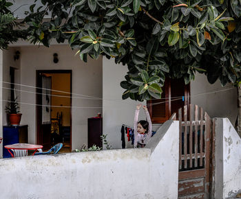 People standing by tree against building