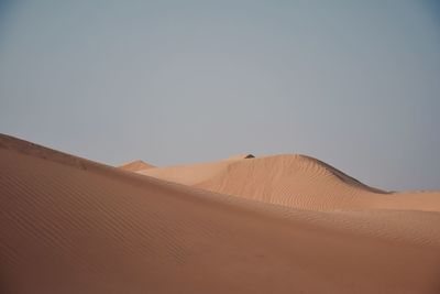 Sand dunes in desert against clear sky