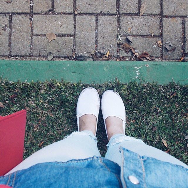 LOW SECTION OF WOMAN RELAXING ON GROUND