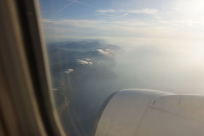 Aerial view of seascape seen through airplane window