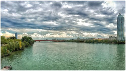 River in city against cloudy sky