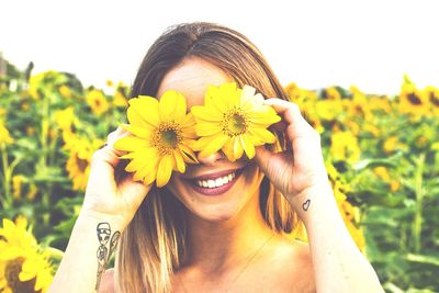 Portrait of smiling young woman by flowering plants