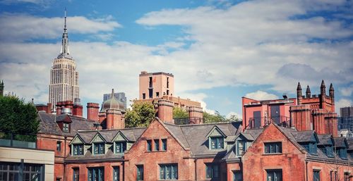Buildings in city against cloudy sky