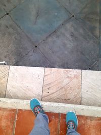 Low section of man standing on tiled floor