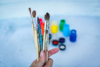 Close-up of hand holding colored pencils