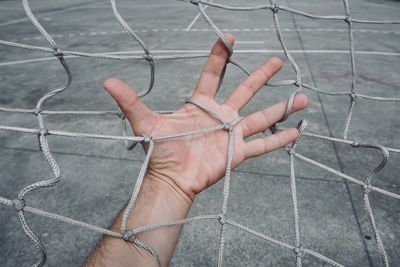 Close-up of hand holding sports net