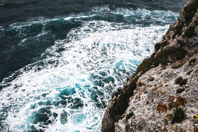 High angle view of waves splashing on rocks