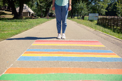 Low section of man standing on road