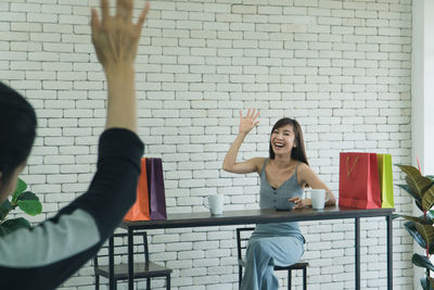 Full length of woman standing against wall