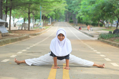 Portrait of girl in traditional clothing practicing taekwondo on road