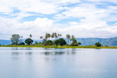 Scenic view of the lake against the mountain and the cloudy sky