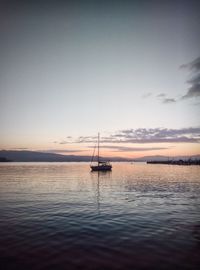 Sailboat on sea against sky during sunset