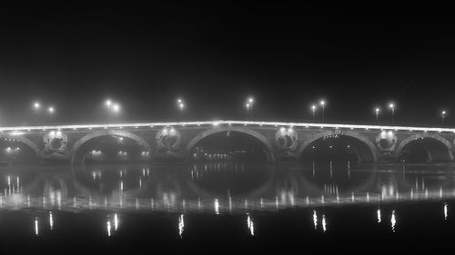 Illuminated bridge against sky at night